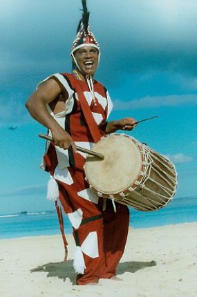 Babasango Playing Drum on Beach